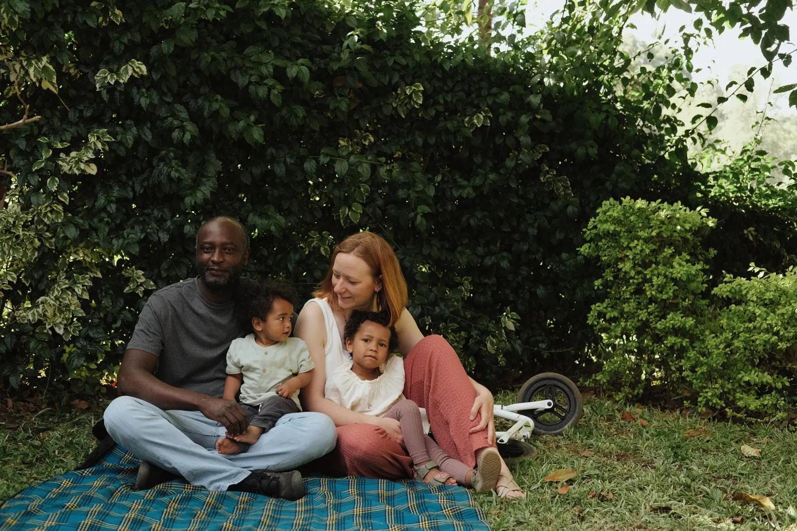 Family sitting together on a picnic blanket in a green Nairobi garden
