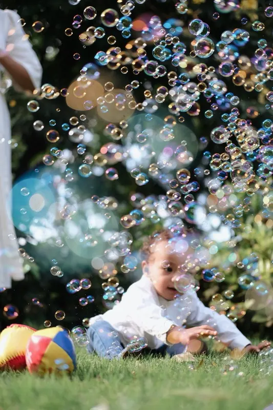 Child playing among floating bubbles